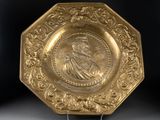 an image of a gold plate with a portrait of a man on it
