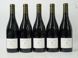 six bouteilles de vin sont alignées sur une surface blanche