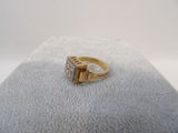 a close up of a gold ring with diamonds on a white surface