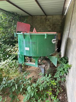 une benne verte posée dans un coin d'un immeuble
