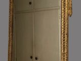 a mirror that has a gold frame on top of it