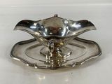 a silver plate with a flower on it sitting on a table
