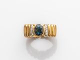une photo d'une bague en or sertie d'un saphir bleu et de diamants