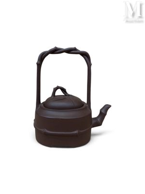 une théière noire avec une anse, sur fond blanc