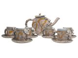 three cups and a teapot sitting on a saucer