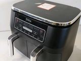 an image of a black and silver air fryer sitting on a counter