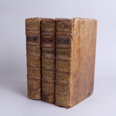two old books sitting on top of each other on a white surface