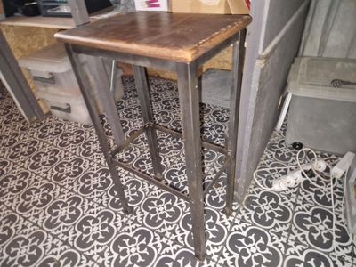 une petite table avec un plateau en bois sur un sol carrelé