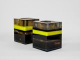 two black and yellow vases sitting next to each other