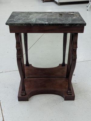 une petite table avec un plateau en marbre, posée à même le sol