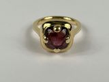 gros plan d'une bague en or avec une pierre rouge