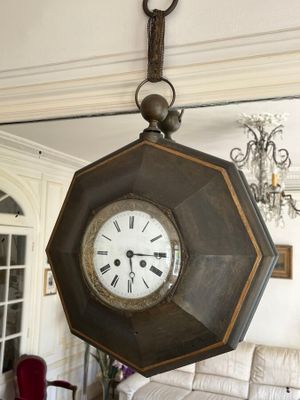 a large clock hanging from the ceiling in a living room