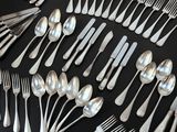 a lot of spoons and forks laid out on a table