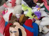 a pile of stuffed animals in a bin on the floor
