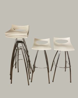 trois tabourets blancs avec des pieds en métal et une assise en bois