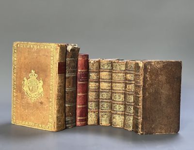 two old books sitting on top of each other on a table