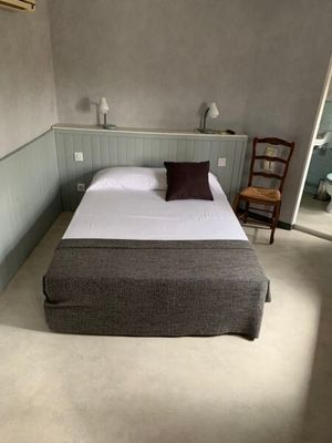 un lit qui se trouve dans une petite pièce avec une chaise