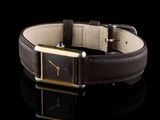 a close up of a watch with a brown leather band