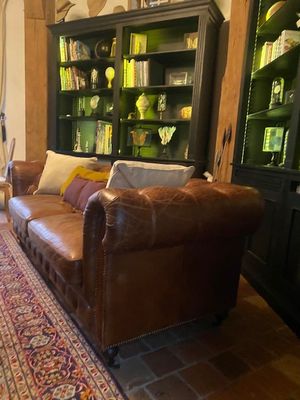 un salon équipé d'un canapé, d'un fauteuil et d'une bibliothèque