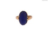 un gros plan d'une bague en or sertie d'un lapis-lazuli