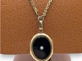 a close up of a necklace with a black stone on it