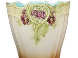 a vase with flowers painted on it sitting on a table