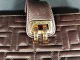 brown quilted purse with a gold buckle on it