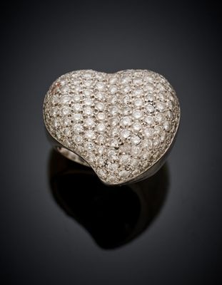 une bague en diamant en forme de cœur posée sur une surface noire