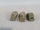 three toy army vehicles that are sitting on a table