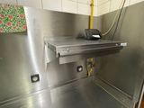 a stainless steel sink in a kitchen with tiled walls