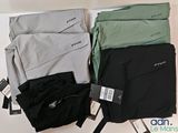 Trois paires de pantalons pour homme sont exposées sur une table