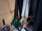 a green blower sitting in the corner of a bathroom