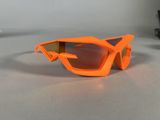 an orange pair of goggles sitting on a table next to a pair of glasses