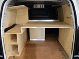 a white van with a desk and shelves in the back of it