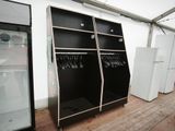two black shelves with clothes hanging on them in a room