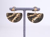 a close up of a pair of earrings on a stand