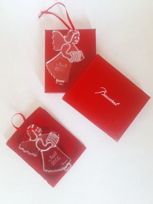 three christmas ornaments in red boxes on a white surface