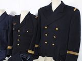 three men ' s military uniforms are lined up on a mannequin