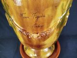 a yellow vase with writing on it sitting on a table
