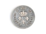 une vieille pièce d'argent surmontée d'une couronne