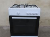 une cuisinière blanche avec un brûleur noir et une porte de four blanche