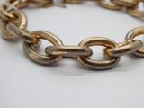 bracelet à chaîne plaqué or, avec maillons et fermoirs, sur fond blanc