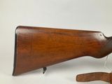 an old wooden rifle with a wooden sling on a white background
