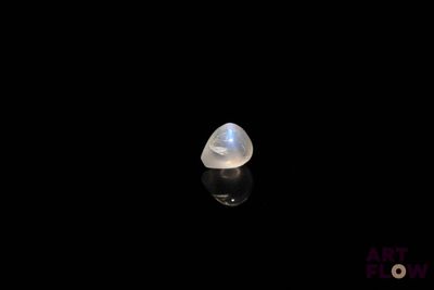 a close up of a white stone on a black surface