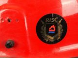 a close up of a red fireman ' s helmet with a badge on it