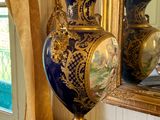 a blue and gold vase sitting on a table in front of a mirror
