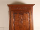 a wooden cabinet with carvings on the top of it
