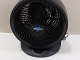 a small black fan sitting on a white table