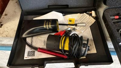 une mallette noire contenant des outils, posée sur une table