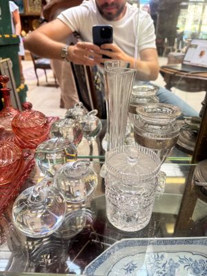 a man taking a picture of a glass vase on a table